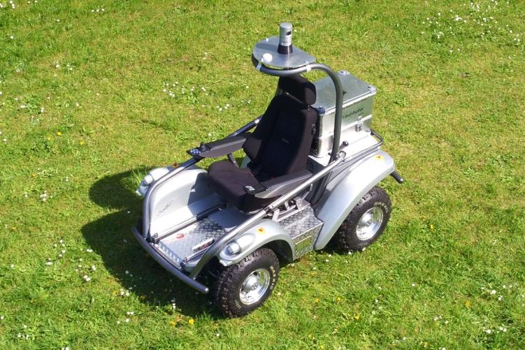 Grey vehicle with black seat on a green meadow