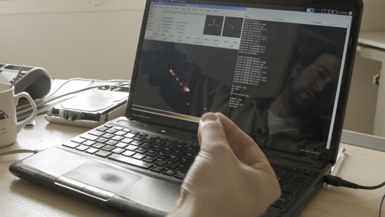 A man reflects in a computer screen