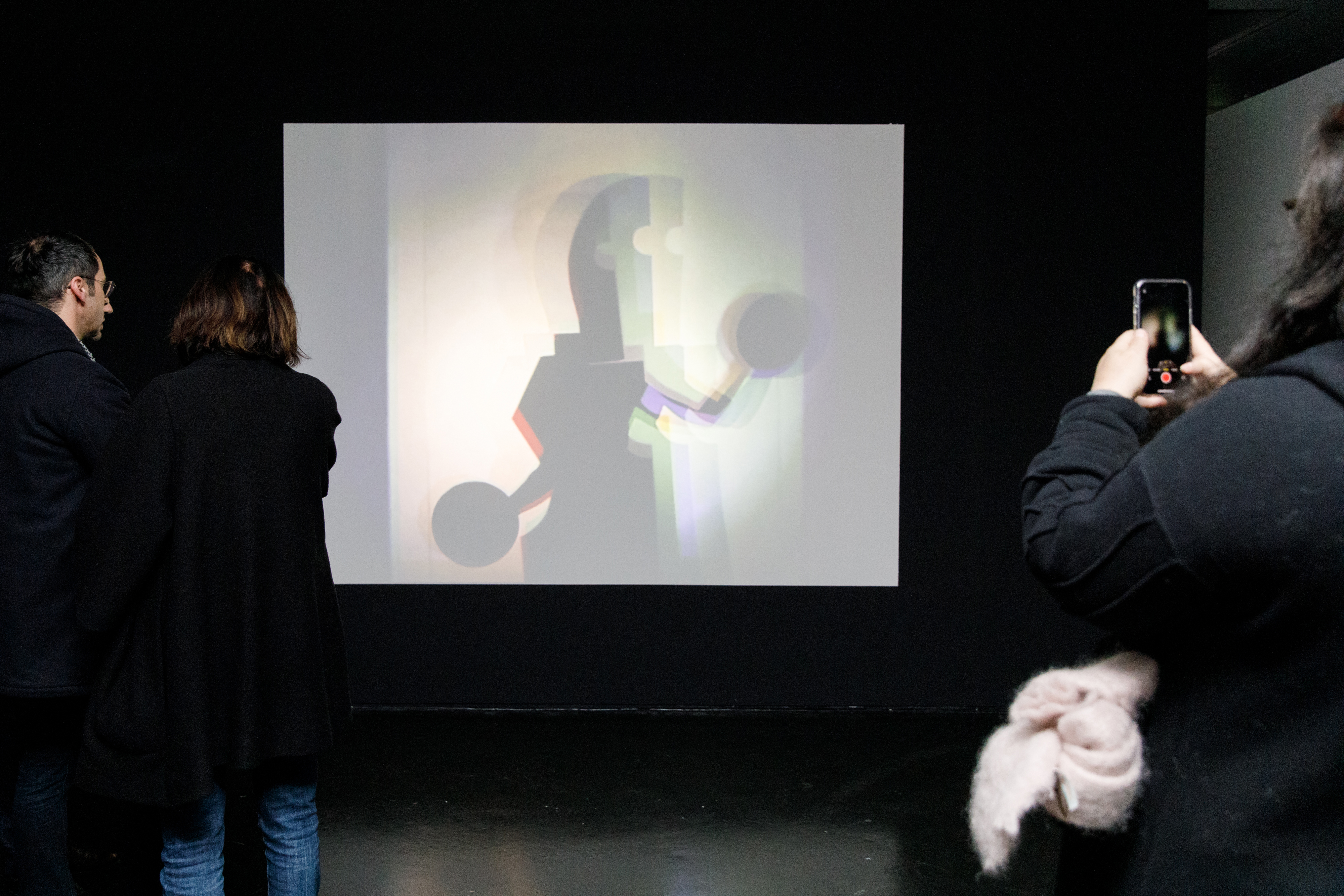 Das Foto zeigt eine große weiße Leinwand auf der eine Bauhaus Figur zu sehen ist.