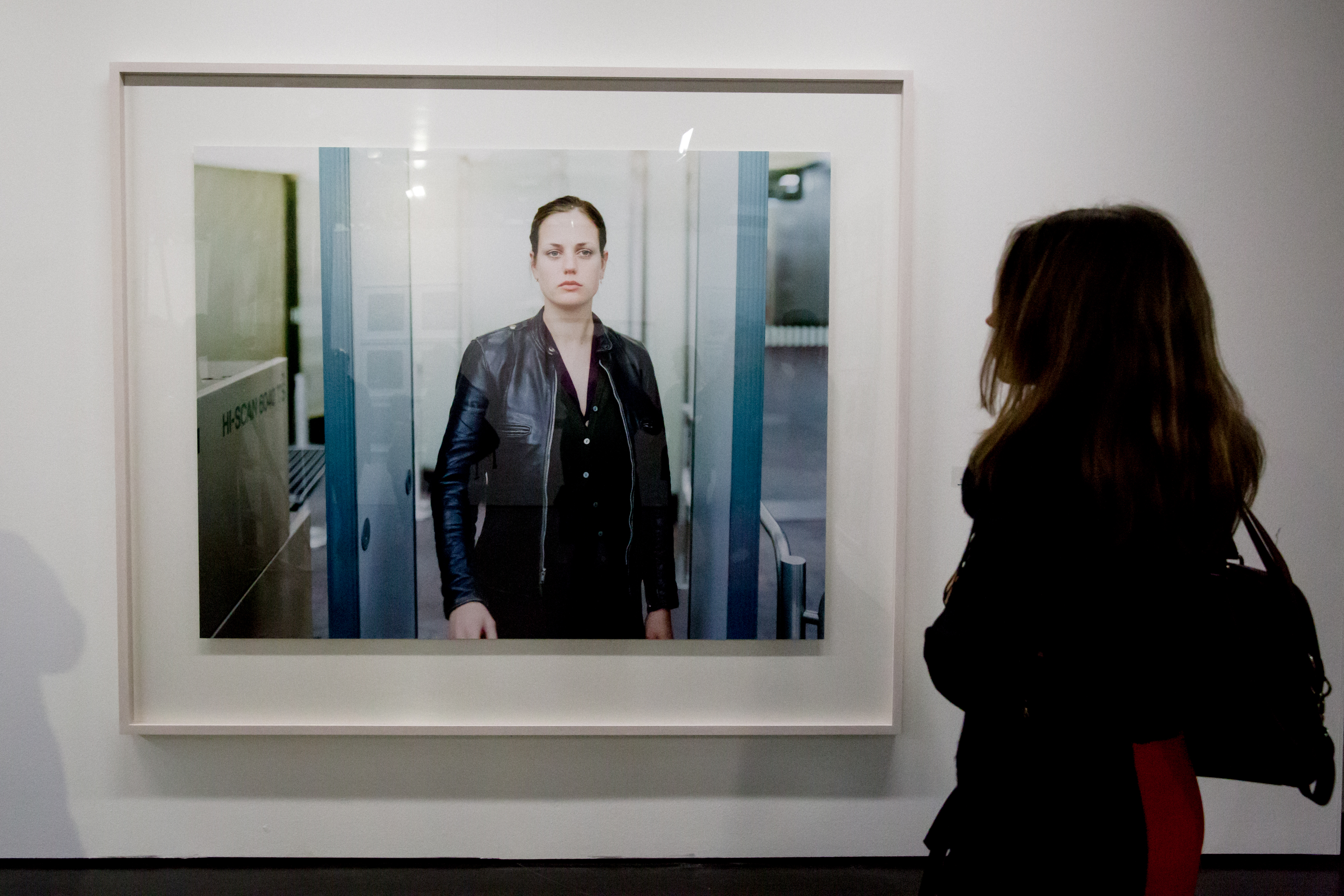 Eine Frau steht vor einer Fotografie