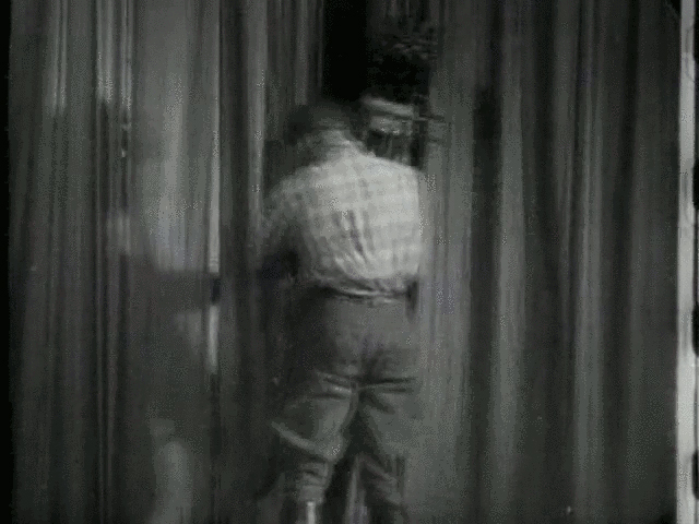 The screenshot shows a black and white picture of a man with his back turned towards the viewer. The image is blurry.