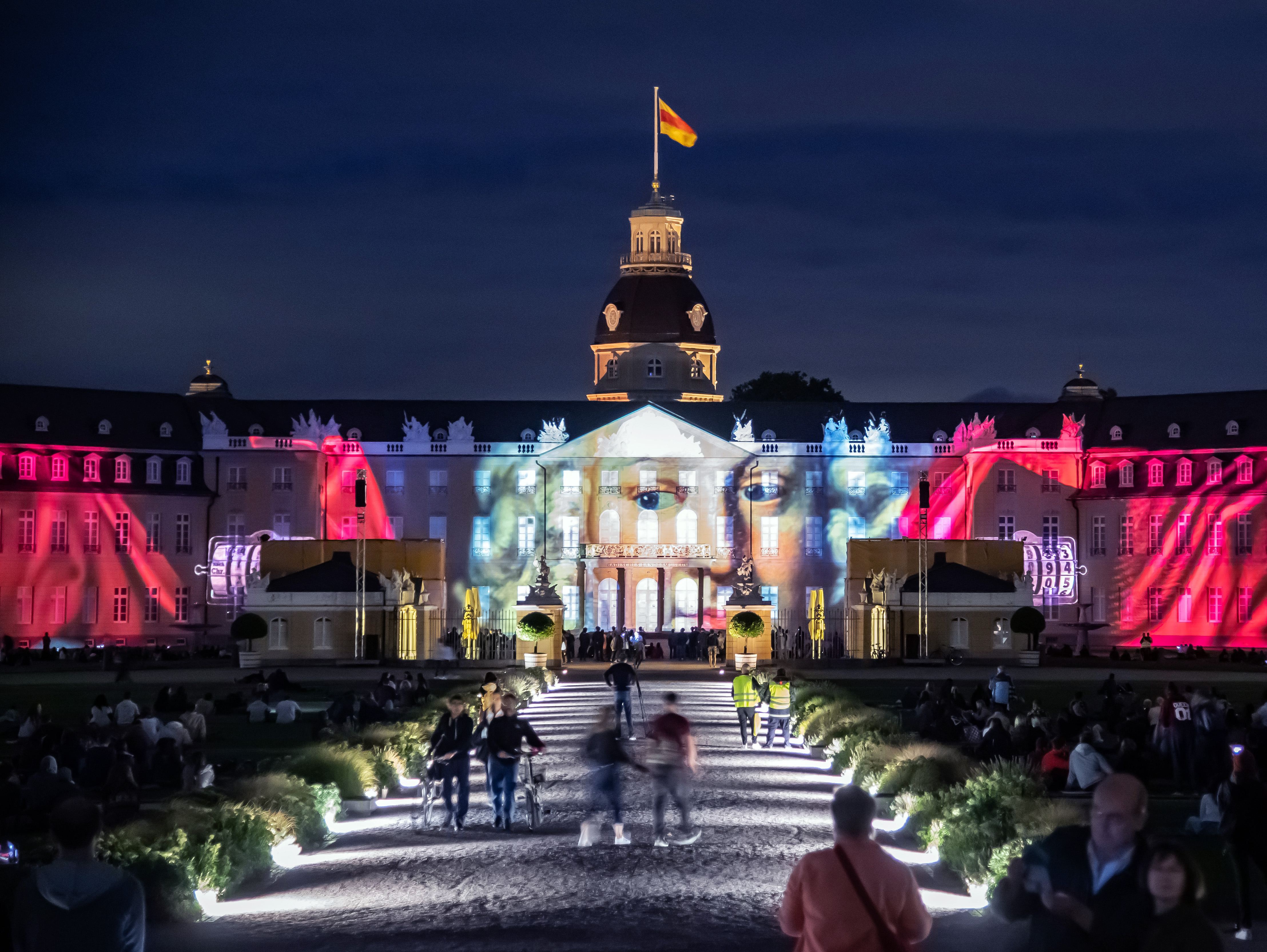 Photo of a colorful projection mapping at night on the baroque Karlsruhe castle.