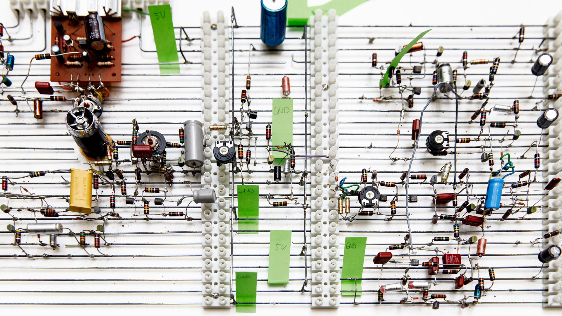 Blick auf eine Gitterstruktur mit Kondensatoren und anderen elektronischen Elementen.