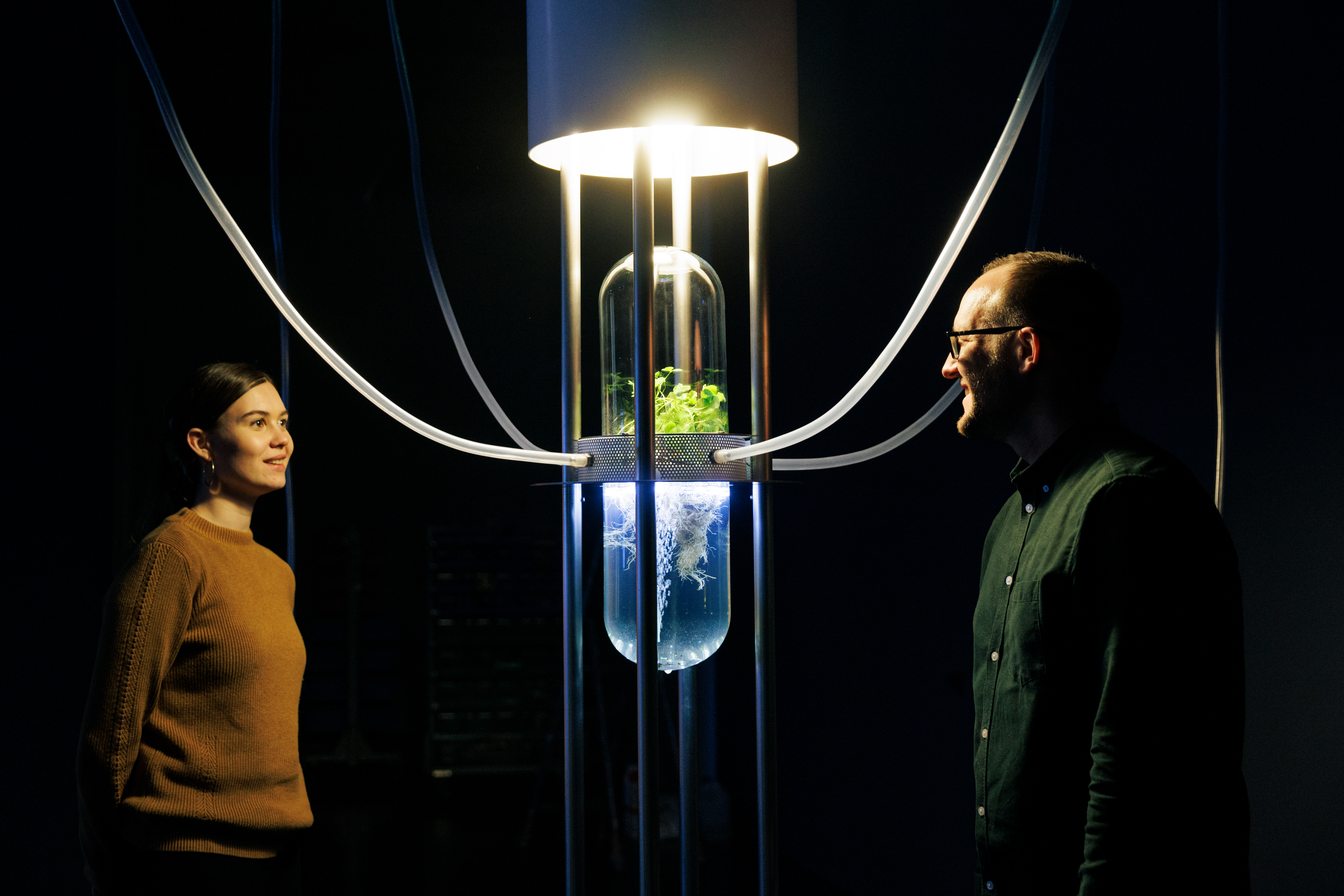 You can see a glass dome, in which is Klee. Several transparent tubes are attached to the glass dome. Two people are looking at this.