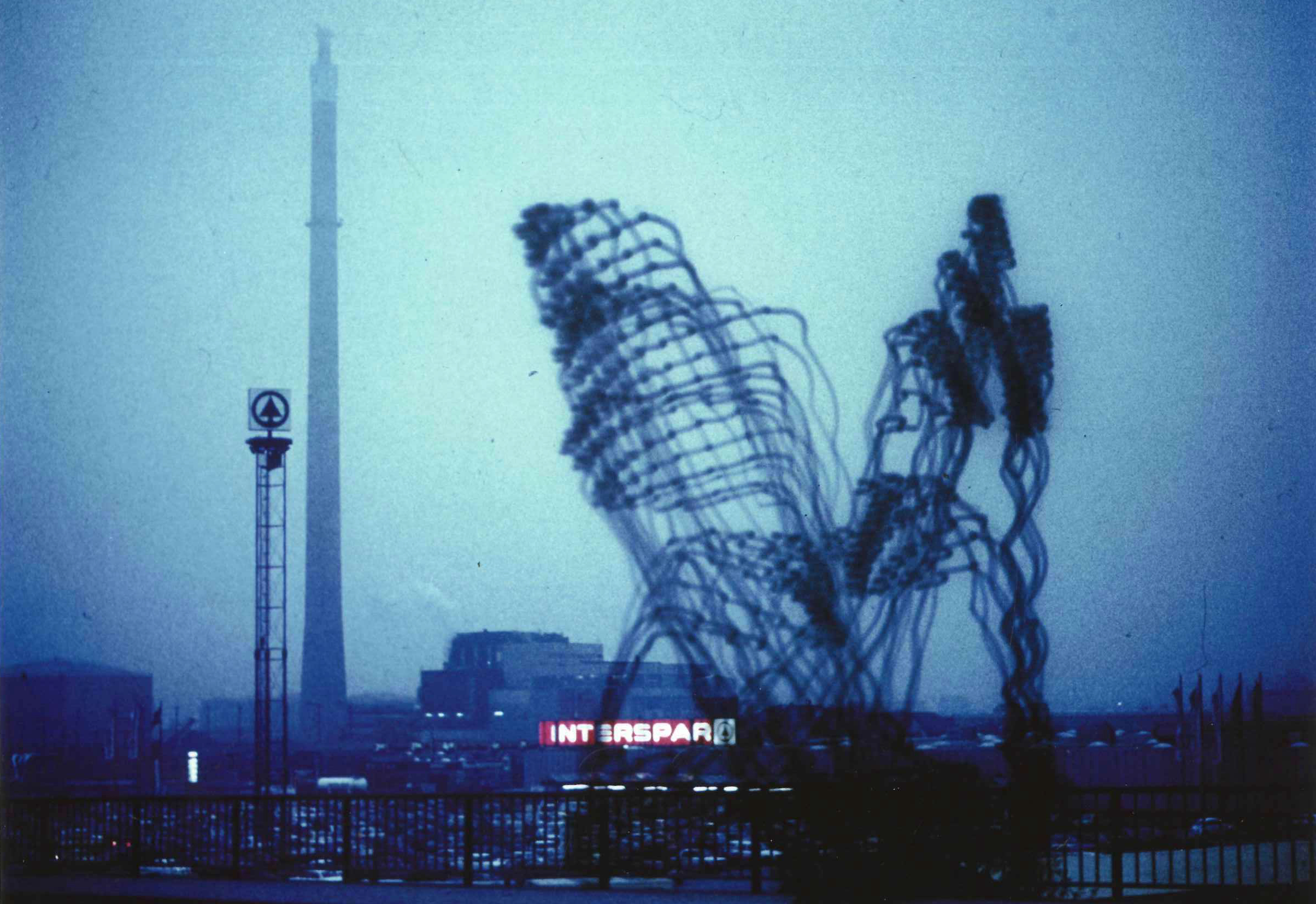 »Imaginäre Architekturen« by Otto Beckmann. A cloudy skyline can be seen. Two large, figurative architectures form the main feature.