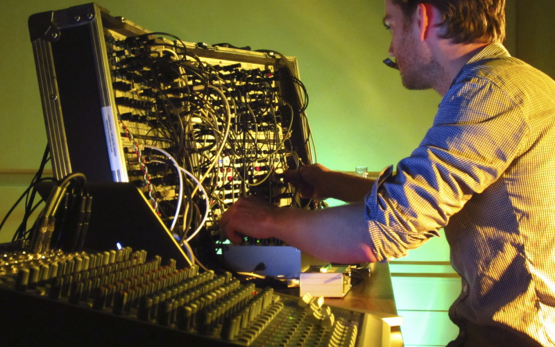 A man sits in front of a sound mixer