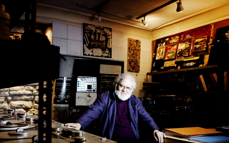 A man sits amid several turntables