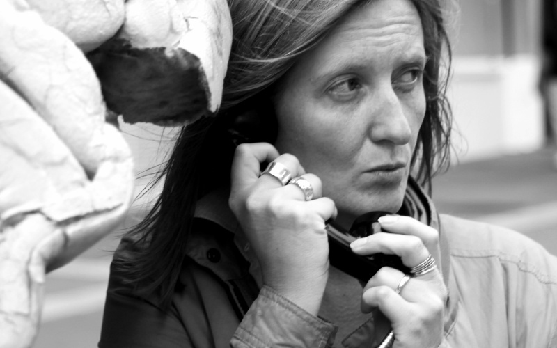 A black and white photo of a woman holding a corded phone