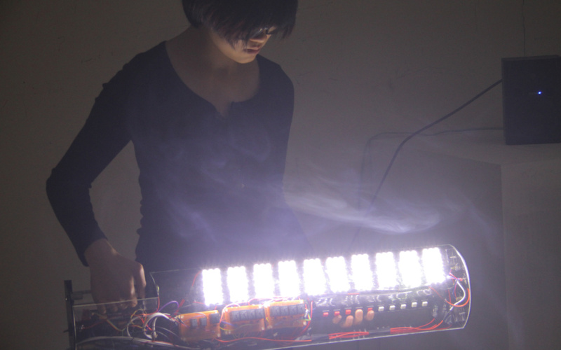 A woman on a self-built, illuminating instrument