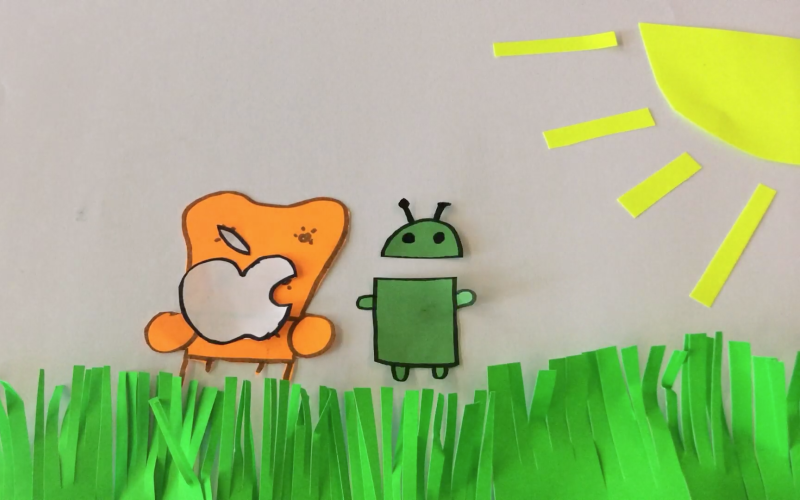 Still of an animation workshop in which the bitten apple sits on a cosy chair next to the android-mascot.