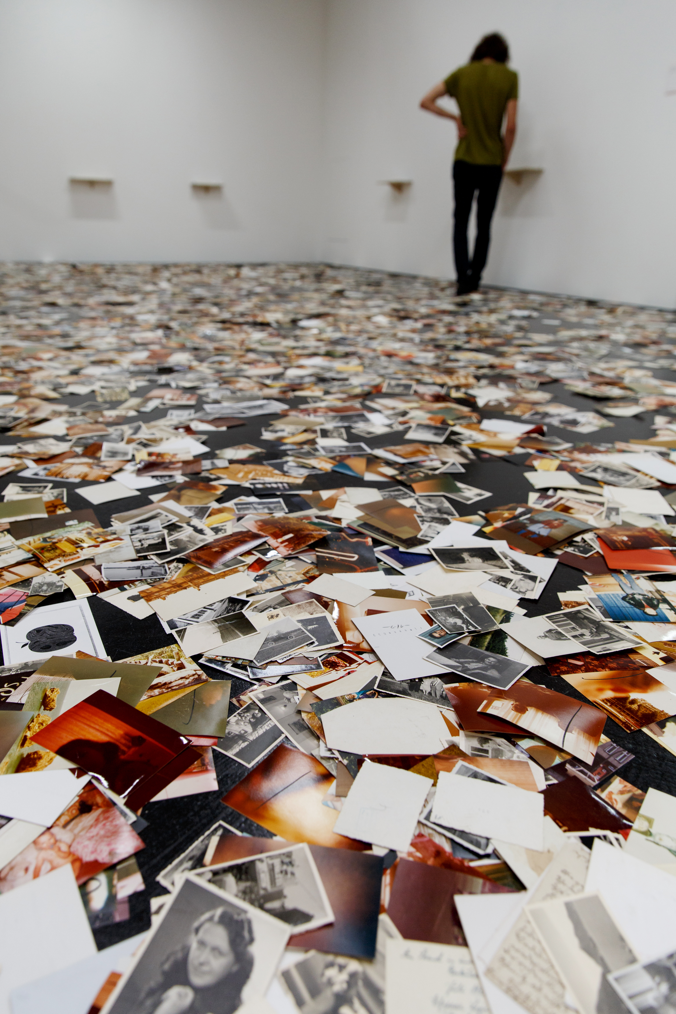 An installation by Dieter Hacker. Colored photographs are distributed on the floor of the exhibition space.