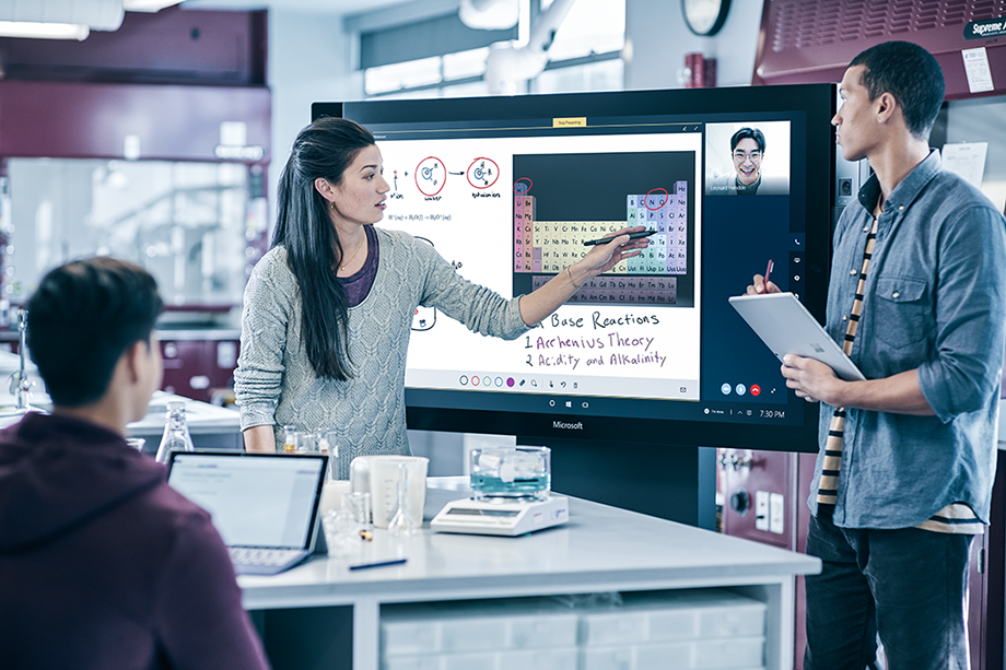 Three people working on a digital screen