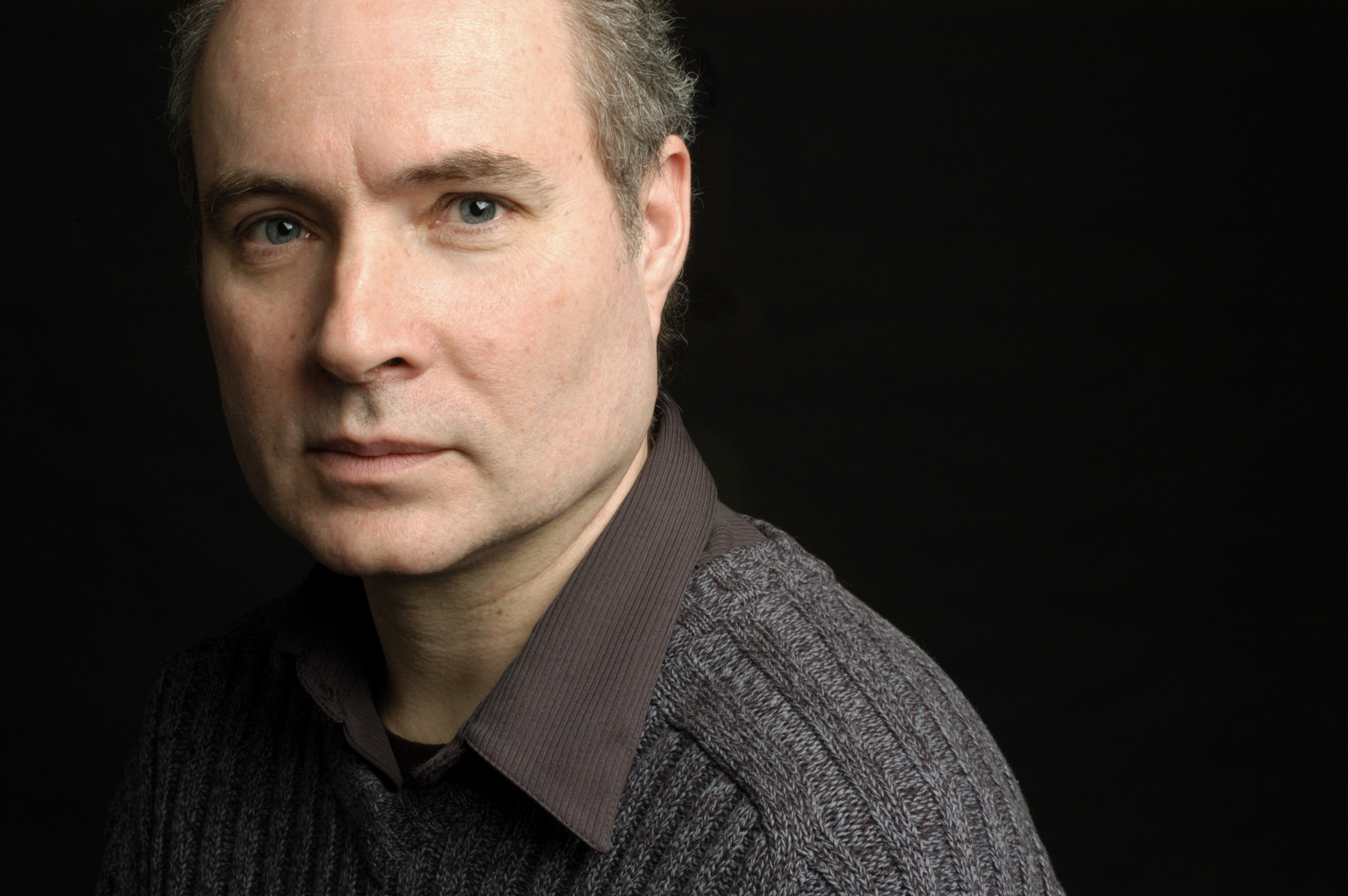 Portrait of a man in front of a black background