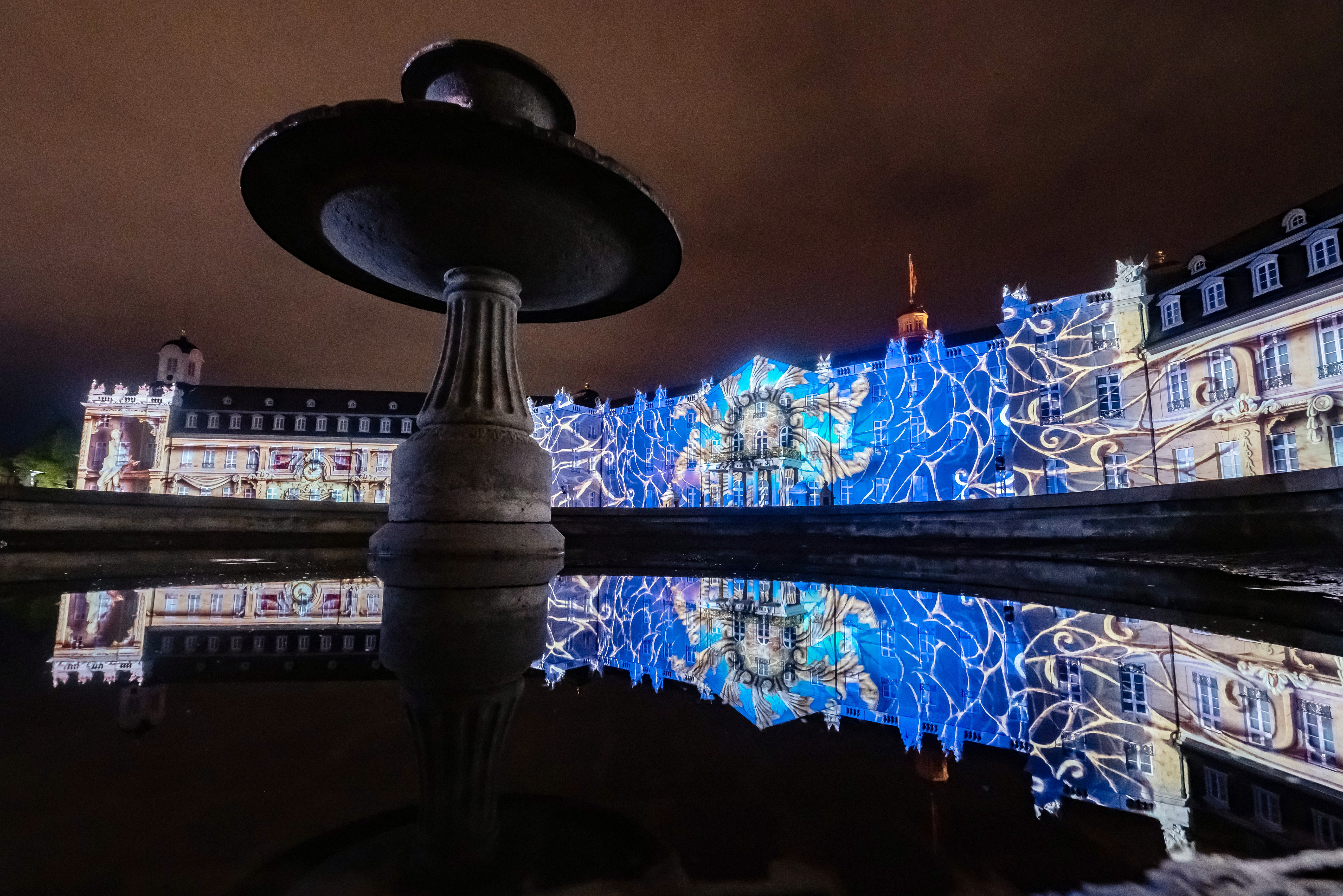 Foto eines bunten Projection Mappings bei Nacht auf dem barocken Karlsruher Schloss.