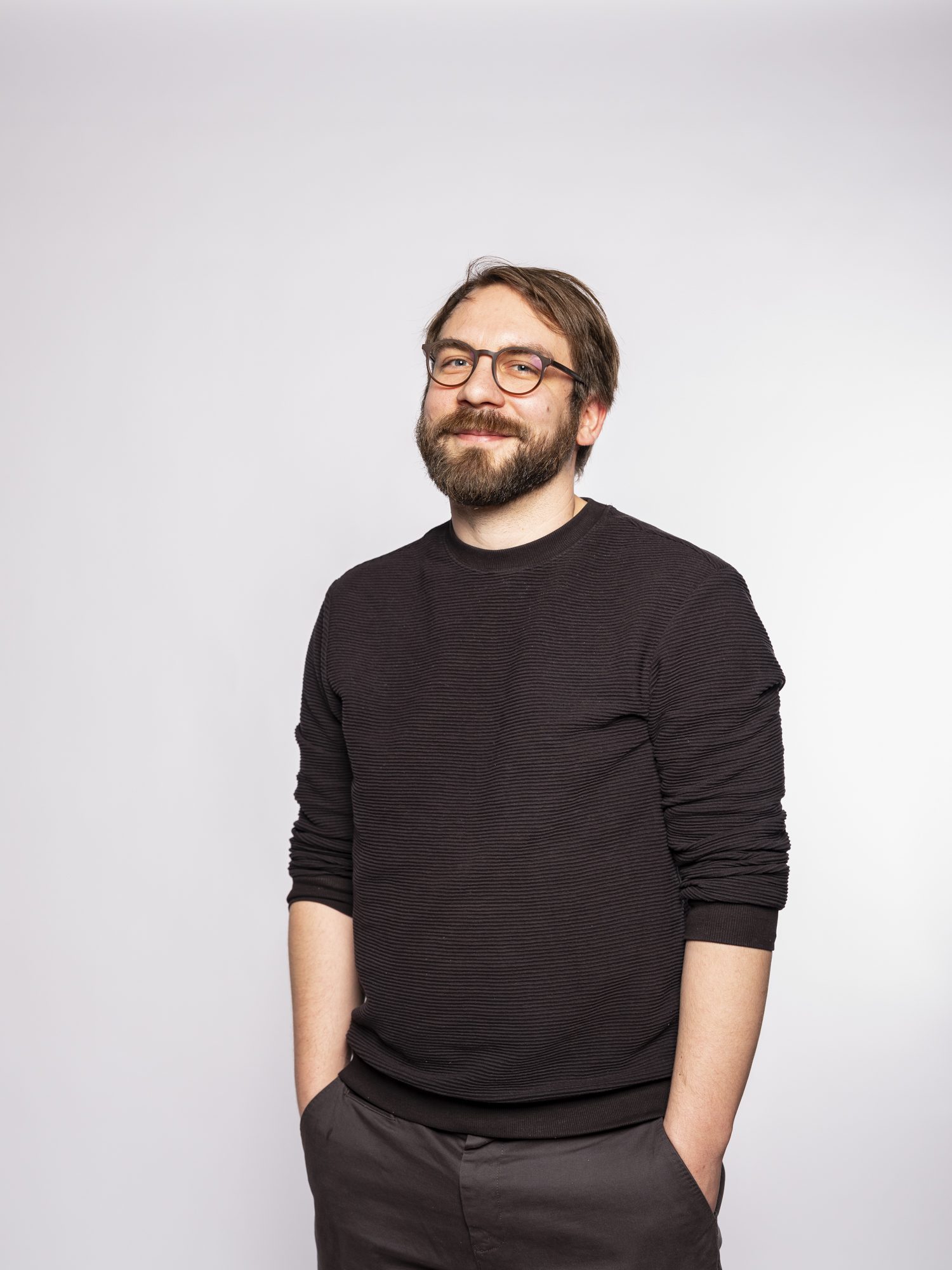 standing man with black shirt and glasses