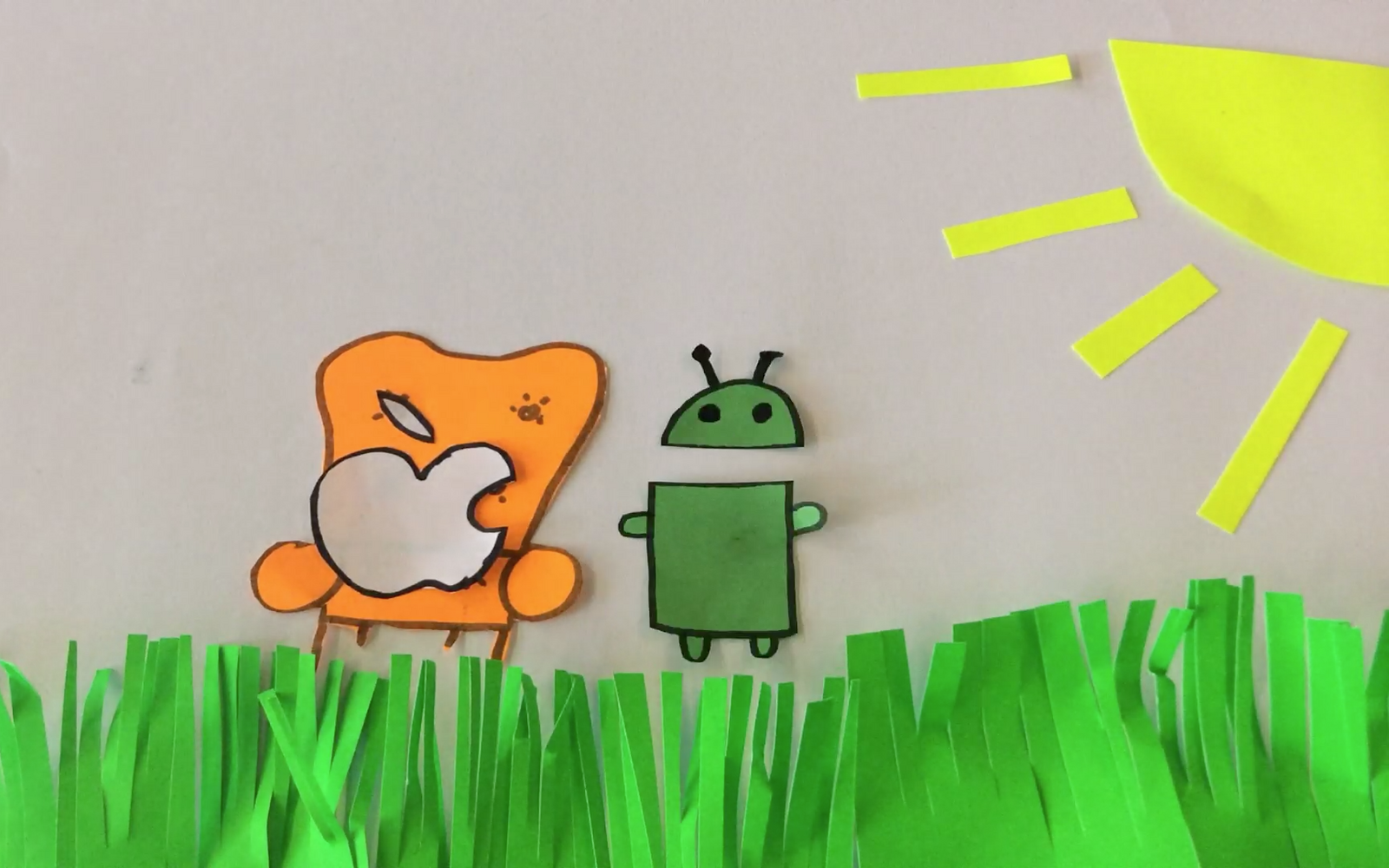 Still of an animation workshop in which the bitten apple sits on a cosy chair next to the android-mascot.