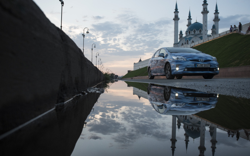 A blue car next to a water puddle